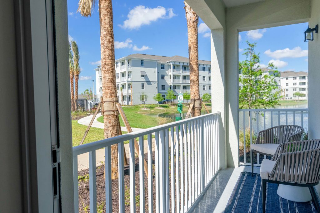 Balcony view with lounge seating, tropical landscaping, and roof covering
