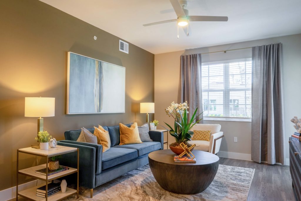 Living room with ceiling fan, couch and lounge seating, designer and natural lighting, and wood-style flooring
