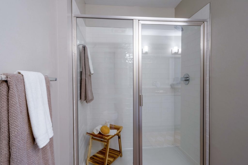 Bathroom with a stand-in shower, designer lighting, towels, and granite flooring